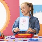 Girl showing her drawing made with Spirograph Jr.
